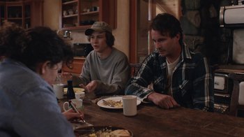 Movie still from “Night Moves” (2013), directed by Kelly Reichardt – A group of people sitting around a table eating food; Medium shot, Over the shoulder angle