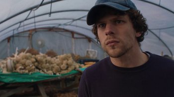Movie still from “Night Moves” (2013), directed by Kelly Reichardt – A man wearing a hat standing in front of a pile of mushrooms; Close Up shot, Over the shoulder angle