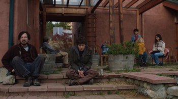 Movie still from “Night Moves” (2013), directed by Kelly Reichardt – A man sitting on the steps of a house; Wide shot, Over the shoulder angle