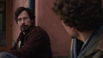 Movie still from “Night Moves” (2013), directed by Kelly Reichardt – A man sitting next to another man on a ledge; Close Up shot, Over the shoulder angle