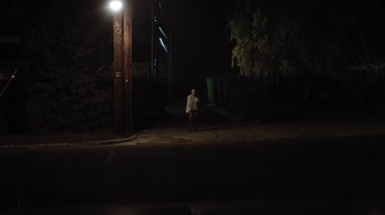 Movie still from “Night Moves” (2013), directed by Kelly Reichardt – A man standing in the dark under a street light; Extreme Wide shot, Low angle