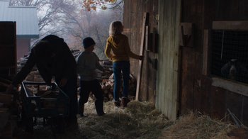 Movie still from “Night Moves” (2013), directed by Kelly Reichardt – Two people standing next to a barn with hay; Wide shot, Over the shoulder angle