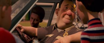 Movie still from “Monster House” (2006), directed by Gil Kenan – A man in a cop uniform sitting in the back of a car; Close Up shot, Over the shoulder angle