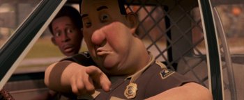 Movie still from “Monster House” (2006), directed by Gil Kenan – A man in a police officer uniform with a badge around his neck; Close Up shot, Low angle