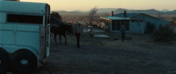 Movie still from “No Country for Old Men” (2007), directed by Joel Coen – A man leading a horse in a field; Wide shot, Low angle