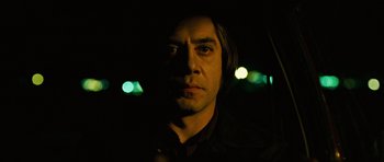 Movie still from “No Country for Old Men” (2007), directed by Joel Coen – A person in a car at night; Close Up shot, Low angle