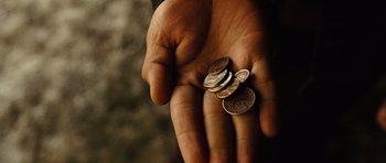 Movie still from “No Country for Old Men” (2007), directed by Joel Coen – A person holding a bunch of coins in their hand; Extreme Close Up shot, High angle