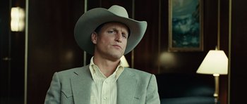 Movie still from “No Country for Old Men” (2007), directed by Joel Coen – A man wearing a cowboy hat and a suit; Close Up shot, Over the shoulder angle