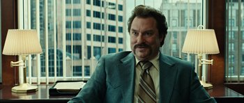 Movie still from “No Country for Old Men” (2007), directed by Joel Coen – A person wearing a suit and tie; Close Up shot, Over the shoulder angle