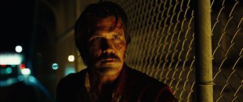 Movie still from “No Country for Old Men” (2007), directed by Joel Coen – A man with blood all over his face and chest; Close Up shot, Low angle