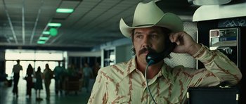 Movie still from “No Country for Old Men” (2007), directed by Joel Coen – A man with a cowboy hat on talking on a phone; Close Up shot, Over the shoulder angle