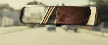 Movie still from “No Country for Old Men” (2007), directed by Joel Coen – A man looking out of the window of a car; Close Up shot, Over the shoulder angle