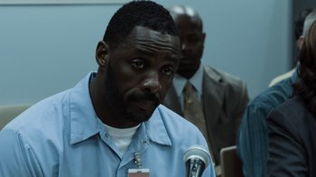 Movie still from “No Good Deed” (2014), directed by Sam Miller – A man that is sitting in front of a microphone; Close Up shot, Over the shoulder angle