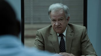Movie still from “No Good Deed” (2014), directed by Sam Miller – An older man wearing a suit and tie sitting at a table; Close Up shot, Over the shoulder angle