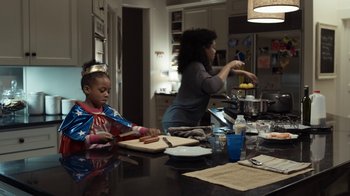 Movie still from “No Good Deed” (2014), directed by Sam Miller – A woman and a child preparing a hot dog on a cutting board; Medium shot, Low angle