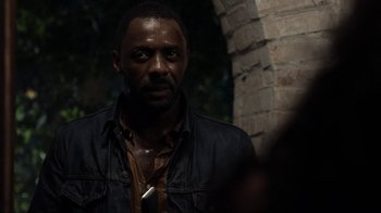Movie still from “No Good Deed” (2014), directed by Sam Miller – A man in a black jacket is standing in front of a brick wall; Close Up shot, Over the shoulder angle
