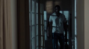 Movie still from “No Good Deed” (2014), directed by Sam Miller – A man standing in front of a window in a dark room; Medium shot, Low angle