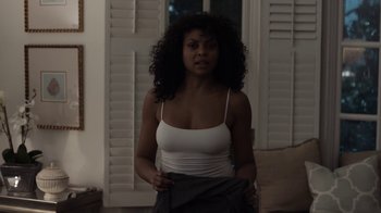 Movie still from “No Good Deed” (2014), directed by Sam Miller – A woman in a white top holding a black skirt; Medium shot, Over the shoulder angle