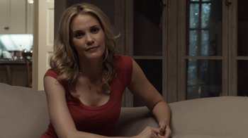 Movie still from “No Good Deed” (2014), directed by Sam Miller – A woman in a red shirt sitting on top of a couch; Medium shot, Over the shoulder angle