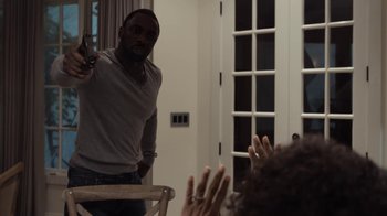 Movie still from “No Good Deed” (2014), directed by Sam Miller – A man standing in front of a group of people; Medium shot, Over the shoulder angle