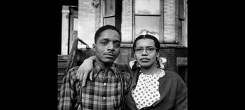 Movie still from “No Sudden Move” (2021), directed by Steven Soderbergh – An old photo of a man and a woman posing for a picture; Medium shot, Low angle