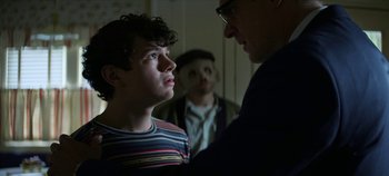 Movie still from “No Sudden Move” (2021), directed by Steven Soderbergh – A group of people standing next to each other in a room; Close Up shot, Over the shoulder angle