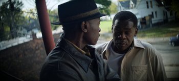 Movie still from “No Sudden Move” (2021), directed by Steven Soderbergh – Two men are talking to each other outside; Close Up shot, Over the shoulder angle