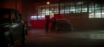 Movie still from “No Sudden Move” (2021), directed by Steven Soderbergh – A couple of men standing next to a car; Extreme Wide shot, Low angle
