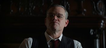 Movie still from “No Sudden Move” (2021), directed by Steven Soderbergh – An older man wearing a suit and tie; Close Up shot, Low angle