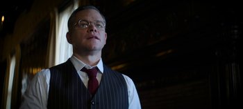 Movie still from “No Sudden Move” (2021), directed by Steven Soderbergh – A man wearing a vest and a red tie; Close Up shot, Low angle