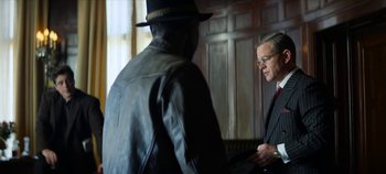 Movie still from “No Sudden Move” (2021), directed by Steven Soderbergh – A man in a suit and hat talking to another man in a suit and hat; Medium shot, Over the shoulder angle