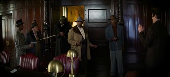 Movie still from “No Sudden Move” (2021), directed by Steven Soderbergh – A group of men standing next to each other in a room; Wide shot, Low angle