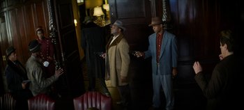 Movie still from “No Sudden Move” (2021), directed by Steven Soderbergh – A couple of men standing next to each other holding wii remotes; Wide shot, Low angle