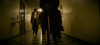 Movie still from “No Sudden Move” (2021), directed by Steven Soderbergh – A group of people walking down a hallway; Wide shot, Low angle