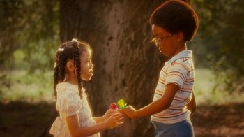 Movie still from “Norbit” (2007), directed by Brian Robbins – Two young children are holding flowers in their hands; Close Up shot, Over the shoulder angle