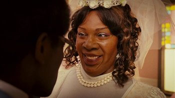 Movie still from “Norbit” (2007), directed by Brian Robbins – An older woman wearing a tiara and a necklace; Close Up shot, Over the shoulder angle