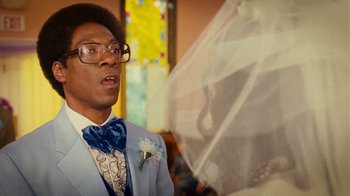 Movie still from “Norbit” (2007), directed by Brian Robbins – A man wearing a suit and bow tie and glasses; Close Up shot, Low angle