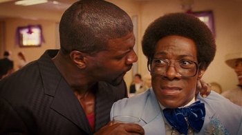Movie still from “Norbit” (2007), directed by Brian Robbins – A man and a woman standing next to each other holding a glass; Close Up shot, Over the shoulder angle