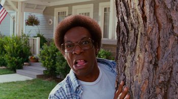 Movie still from “Norbit” (2007), directed by Brian Robbins – A man with glasses leaning against a tree; Close Up shot, Low angle