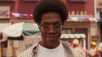 Movie still from “Norbit” (2007), directed by Brian Robbins – A person wearing glasses and smiling; Close Up shot, Over the shoulder angle