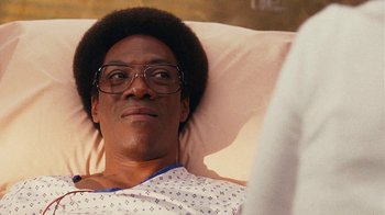 Movie still from “Norbit” (2007), directed by Brian Robbins – A man in a hospital bed wearing glasses; Close Up shot, High angle