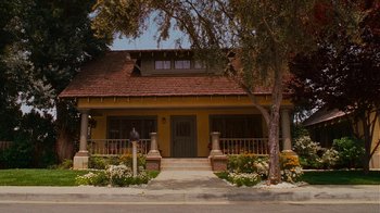 Movie still from “Norbit” (2007), directed by Brian Robbins – A yellow house with flowers in front of it; Extreme Wide shot, Low angle