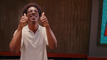 Movie still from “Norbit” (2007), directed by Brian Robbins – A man giving two thumbs up while wearing a white shirt; Medium shot, Low angle