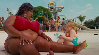 Movie still from “Norbit” (2007), directed by Brian Robbins – A woman sitting on the ground next to a child; Wide shot, High angle