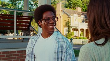 Movie still from “Norbit” (2007), directed by Brian Robbins – A man with glasses smiling for the camera; Close Up shot, Over the shoulder angle