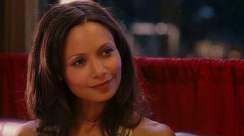 Movie still from “Norbit” (2007), directed by Brian Robbins – A woman sitting on a red chair smiling for the camera; Close Up shot, Over the shoulder angle