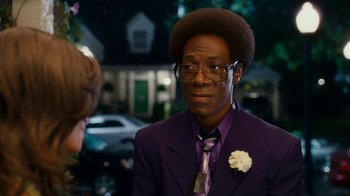 Movie still from “Norbit” (2007), directed by Brian Robbins – A man in a purple suit with a flower in his hair; Close Up shot, Over the shoulder angle