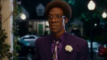 Movie still from “Norbit” (2007), directed by Brian Robbins – A man in a purple suit with a flower in his hair; Close Up shot, Over the shoulder angle