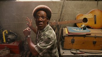 Movie still from “Norbit” (2007), directed by Brian Robbins – A man in a hat and glasses posing for a picture; Close Up shot, High angle