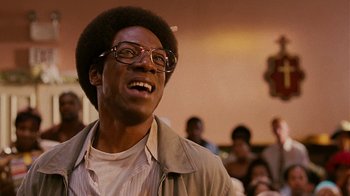 Movie still from “Norbit” (2007), directed by Brian Robbins – A man with glasses is smiling for the camera; Close Up shot, Low angle